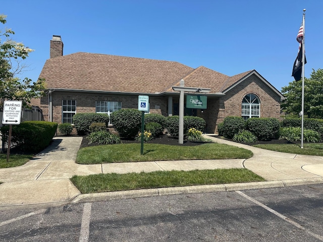 2328 Willowside Ln, Grove City, OH 43123 - view of front of property with brick siding, a chimney, roof with shingles, and uncovered parking