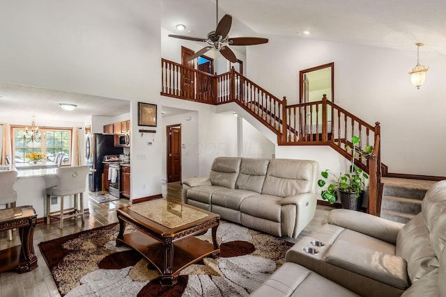 729 Lilly Landing Ln, Blacklick, OH 43004 - living area featuring stairs, wood finished floors, a chandelier, lofted ceiling, and ceiling fan