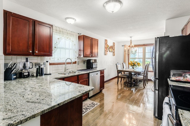 729 Lilly Landing Ln, Blacklick, OH 43004 - kitchen with stainless steel appliances, healthy amount of natural light, backsplash, light wood-type flooring, and a textured ceiling