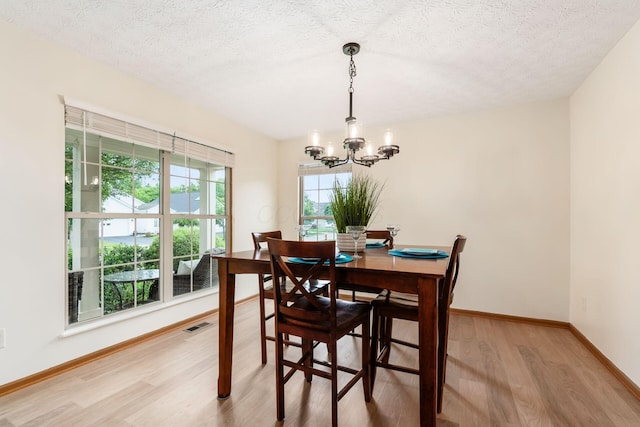1553 Grove Hill Dr, Columbus, OH 43240 - dining area featuring light wood finished floors, a chandelier, and a textured ceiling