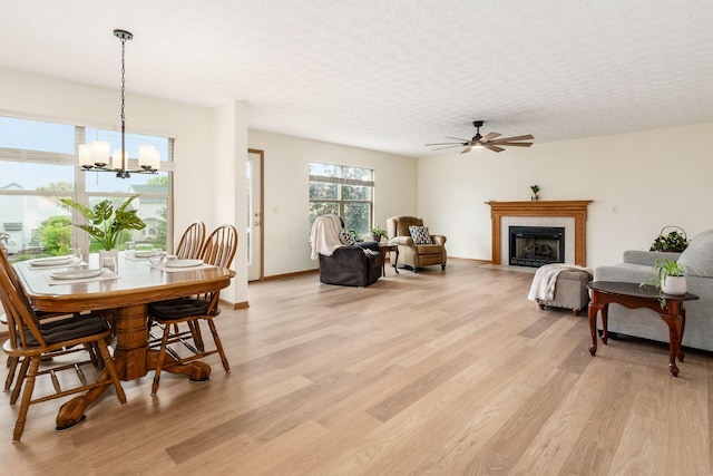 1553 Grove Hill Dr, Columbus, OH 43240 - dining room with light wood-style flooring, a ceiling fan, a chandelier, and a tiled fireplace