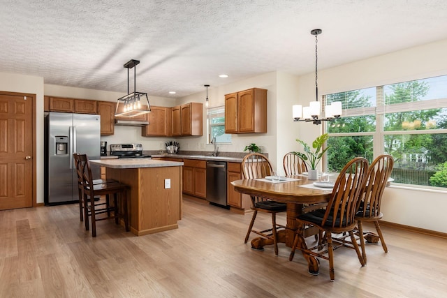 1553 Grove Hill Dr, Columbus, OH 43240 - kitchen featuring appliances with stainless steel finishes, a kitchen island, plenty of natural light, light wood-style flooring, and a textured ceiling
