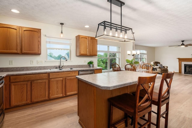 1553 Grove Hill Dr, Columbus, OH 43240 - kitchen with a textured ceiling, a kitchen breakfast bar, light wood-style floors, ceiling fan, and a center island
