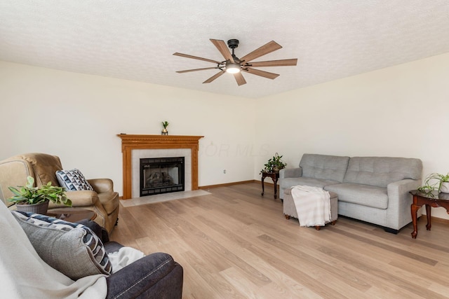 1553 Grove Hill Dr, Columbus, OH 43240 - living room with light wood-style floors, ceiling fan, a fireplace with flush hearth, and a textured ceiling