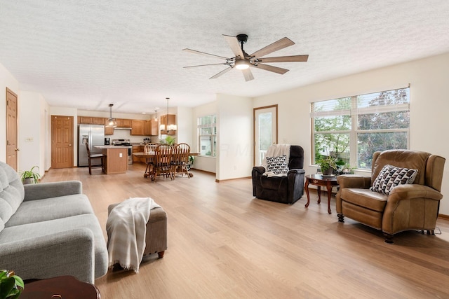 1553 Grove Hill Dr, Columbus, OH 43240 - living area with light wood-style flooring, ceiling fan, healthy amount of natural light, and a textured ceiling