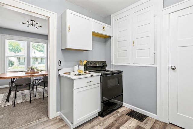 364 Clarendon Ave, Columbus, OH 43223 - kitchen with black electric range oven, light wood-type flooring, white cabinetry, and light countertops