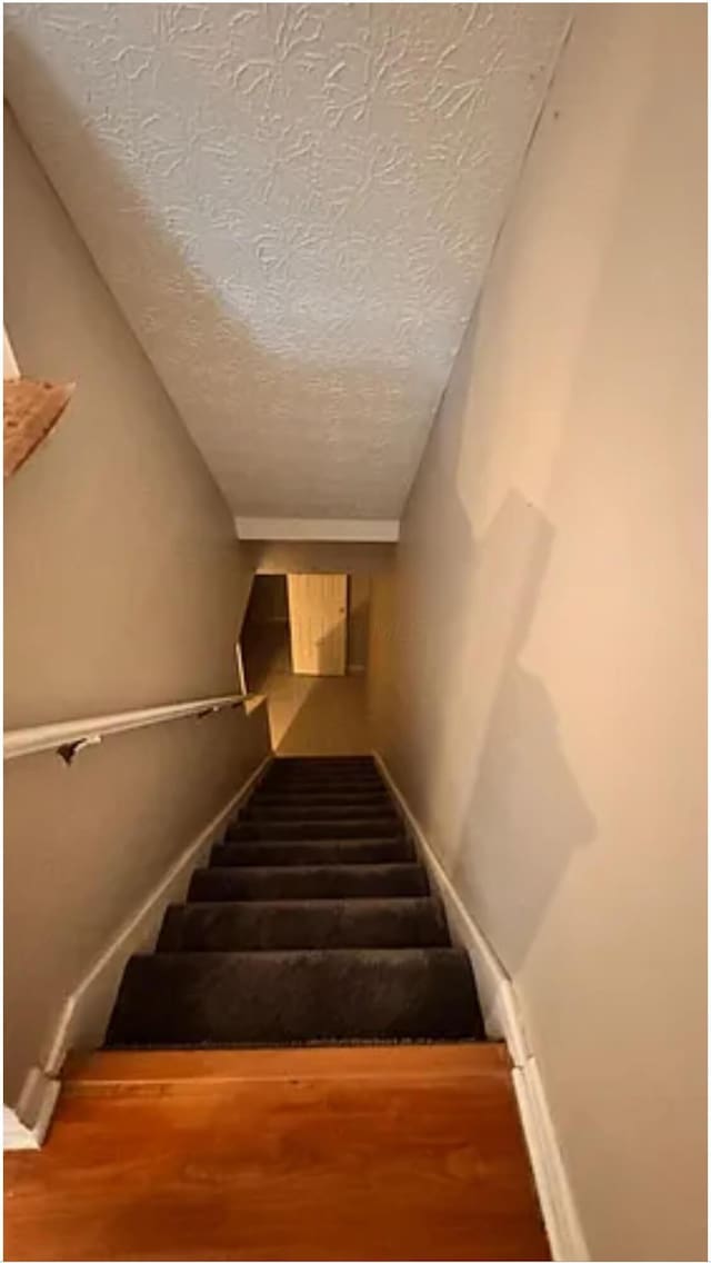 991 Hidden Acres Ct, Columbus, OH 43224 - stairs featuring a textured ceiling and wood finished floors