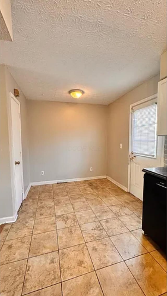 991 Hidden Acres Ct, Columbus, OH 43224 - unfurnished dining area featuring light tile patterned flooring and a textured ceiling