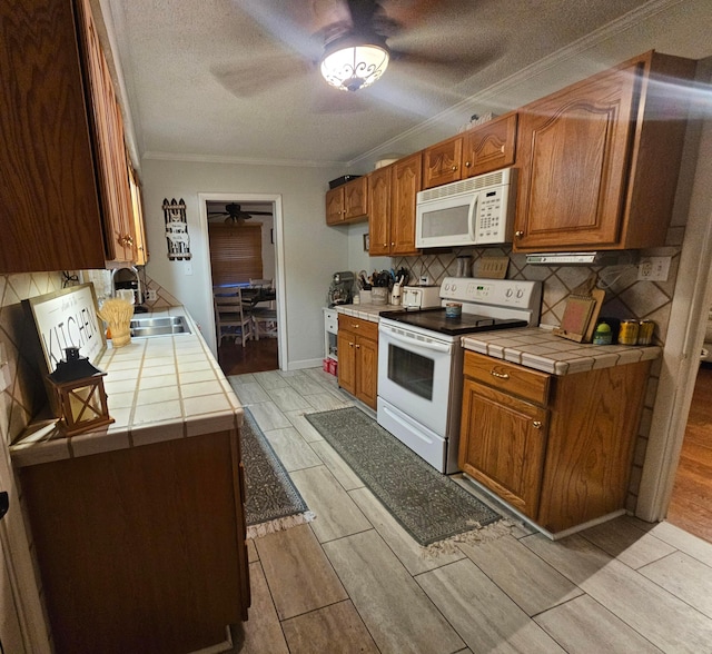 45 Shady Ln Unit 552On, Waverly, OH 45690 - kitchen with white appliances, tile counters, a ceiling fan, crown molding, and wood finish floors