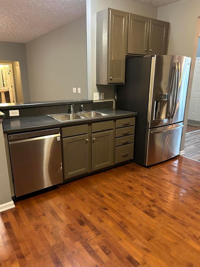 1021 Taylor Glen Blvd E, Pataskala, OH 43062 - kitchen with appliances with stainless steel finishes, dark countertops, a textured ceiling, dark wood-type flooring, and gray cabinetry