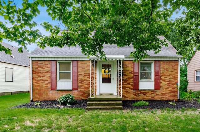 3064 Melva Ave, Columbus, OH 43224 - view of front of property featuring a front lawn, a shingled roof, and brick siding