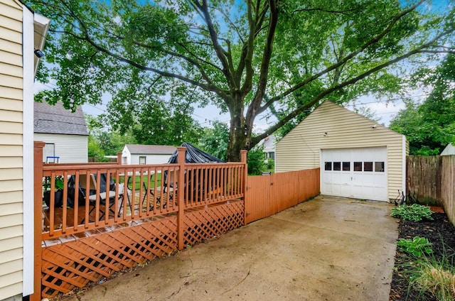 3064 Melva Ave, Columbus, OH 43224 - view of patio / terrace with an outdoor structure, a detached garage, a wooden deck, and driveway