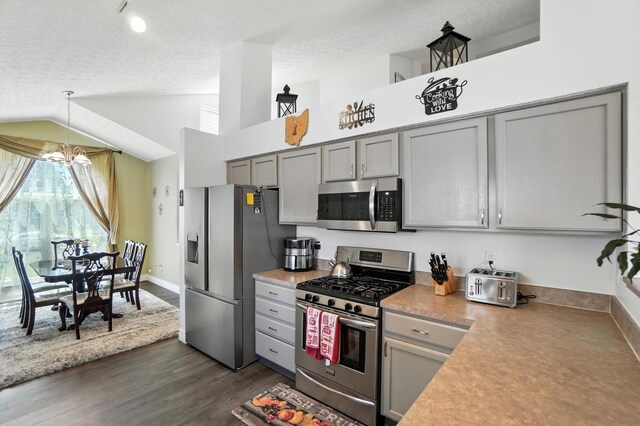906 Linkfield Dr, Columbus, OH 43085 - kitchen with stainless steel appliances, gray cabinetry, vaulted ceiling, dark wood-style flooring, and hanging light fixtures