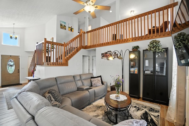906 Linkfield Dr, Columbus, OH 43085 - living room with high vaulted ceiling, stairs, a chandelier, wood finished floors, and a ceiling fan
