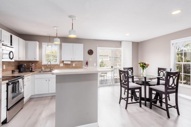 5588 Bow Falls Blvd Unit 35-558, Dublin, OH 43016 - kitchen featuring stainless steel appliances, light wood-style floors, healthy amount of natural light, backsplash, and recessed lighting