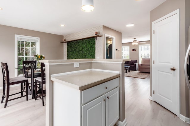5588 Bow Falls Blvd Unit 35-558, Dublin, OH 43016 - kitchen featuring light wood-style flooring, open floor plan, ceiling fan, light countertops, and recessed lighting