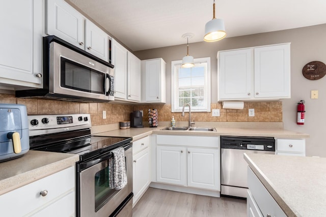 5588 Bow Falls Blvd Unit 35-558, Dublin, OH 43016 - kitchen featuring stainless steel appliances, light countertops, white cabinetry, and decorative light fixtures