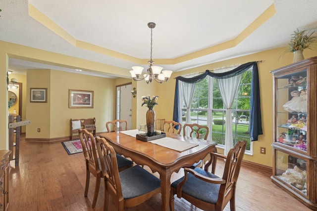 13946 Bainwick Dr NW, Pickerington, OH 43147 - dining room with a tray ceiling, a chandelier, and light wood-type flooring