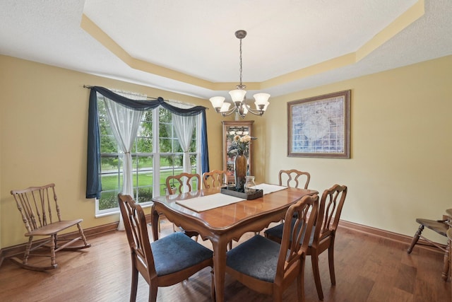 13946 Bainwick Dr NW, Pickerington, OH 43147 - dining space featuring a chandelier, a raised ceiling, and wood finished floors