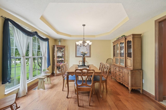 13946 Bainwick Dr NW, Pickerington, OH 43147 - dining space with a raised ceiling, healthy amount of natural light, a chandelier, light wood-type flooring, and a textured ceiling