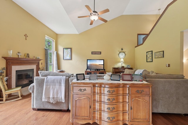 13946 Bainwick Dr NW, Pickerington, OH 43147 - living area with light wood finished floors, a ceiling fan, a tile fireplace, and high vaulted ceiling