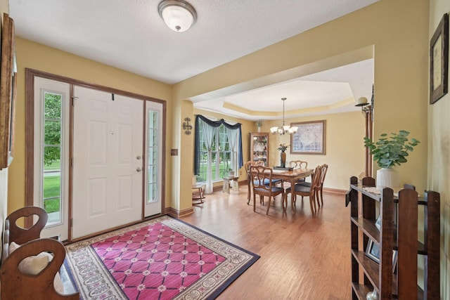 13946 Bainwick Dr NW, Pickerington, OH 43147 - foyer entrance with a chandelier, wood finished floors, a raised ceiling, and a textured ceiling