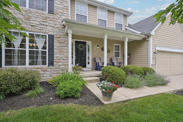 13946 Bainwick Dr NW, Pickerington, OH 43147 - view of front of home with stone siding, a porch, a garage, concrete driveway, and roof with shingles
