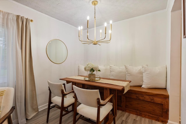 3029 Mcguffey Rd, Columbus, OH 43224 - dining space with wood finished floors, a chandelier, crown molding, and a textured ceiling