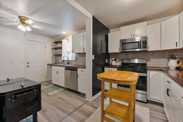 3029 Mcguffey Rd, Columbus, OH 43224 - kitchen with stainless steel appliances, ceiling fan, open shelves, tasteful backsplash, and white cabinetry