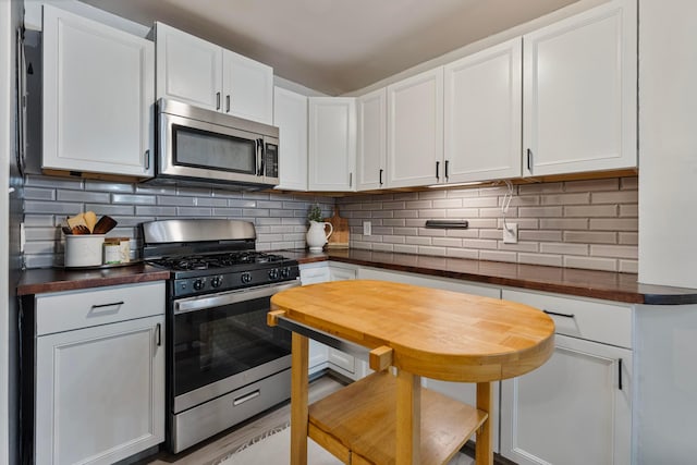 3029 Mcguffey Rd, Columbus, OH 43224 - kitchen with appliances with stainless steel finishes, white cabinets, tasteful backsplash, and butcher block countertops