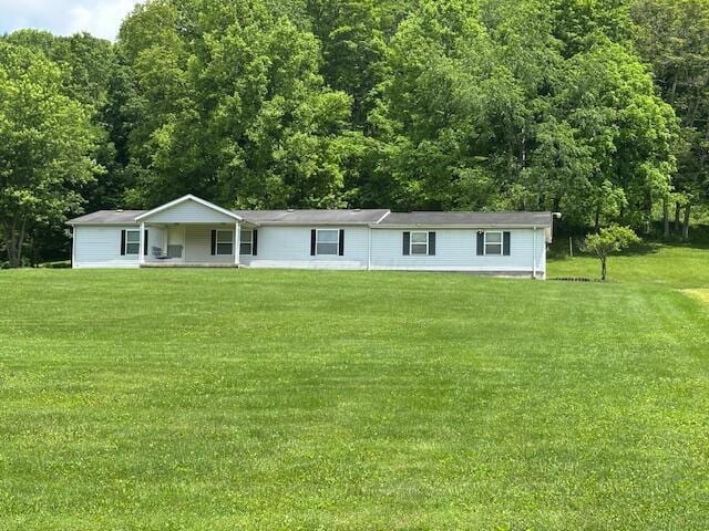 10830 Voris Rd, Logan, OH 43138 - ranch-style home with a front lawn, covered porch, and a forest view