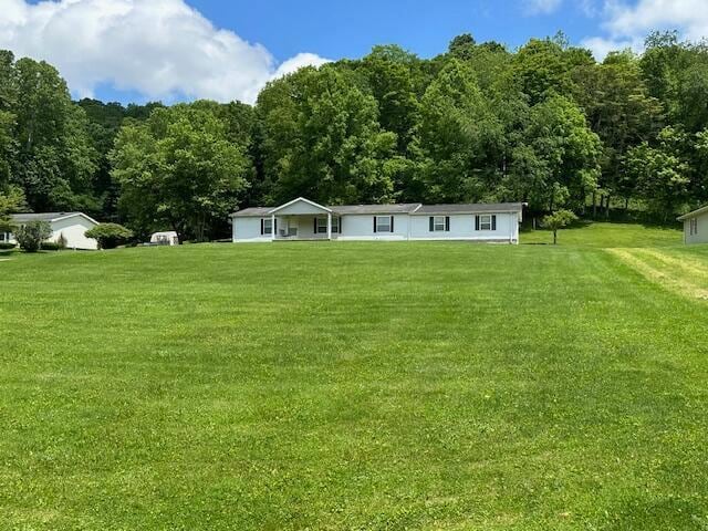 10830 Voris Rd, Logan, OH 43138 - rear view of property featuring a lawn and a wooded view