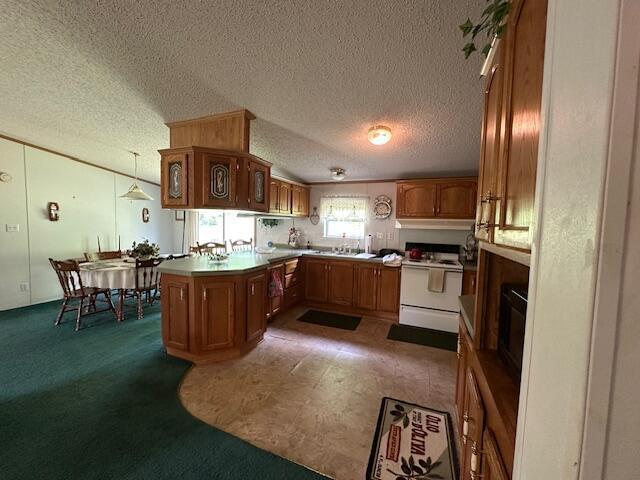 10830 Voris Rd, Logan, OH 43138 - kitchen with electric range, brown cabinets, a textured ceiling, a peninsula, and pendant lighting