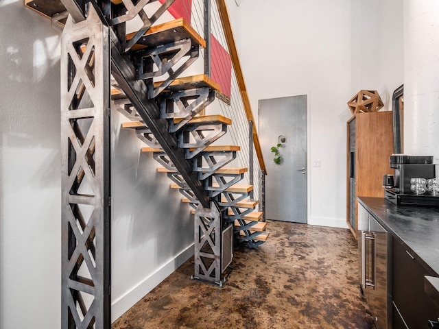 60 E Spring St Unit 214, Columbus, OH 43215 - staircase with concrete floors, beverage cooler, and a towering ceiling