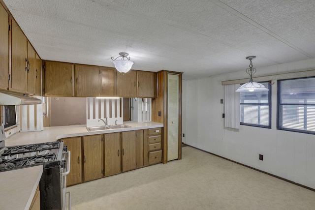 4455 Janice Marie Blvd, Obetz, OH 43207 - kitchen featuring gas range, under cabinet range hood, light countertops, brown cabinetry, and a textured ceiling