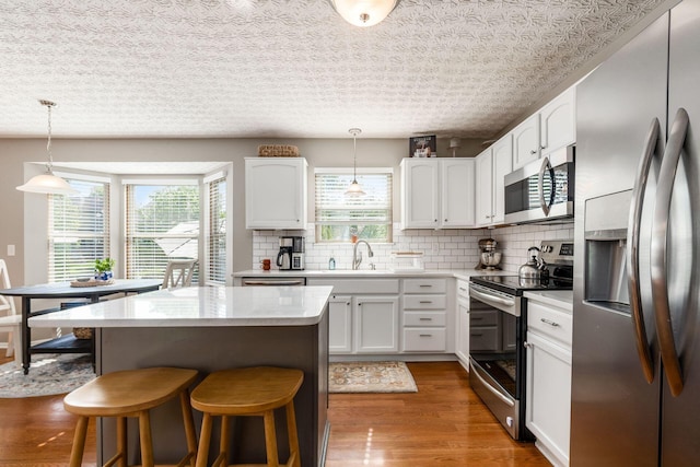 9188 Colonial Commons Dr, Columbus, OH 43240 - kitchen featuring stainless steel appliances, plenty of natural light, a breakfast bar area, and a center island