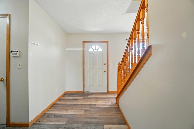 8578 Bivouac Pl, Galloway, OH 43119 - foyer featuring wood finished floors, stairs, and a textured ceiling