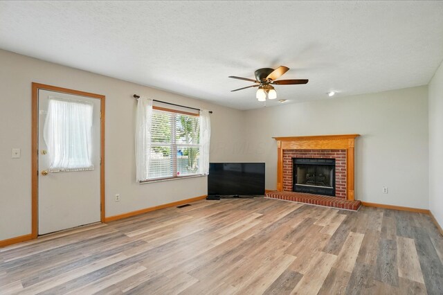 8578 Bivouac Pl, Galloway, OH 43119 - unfurnished living room featuring light wood-type flooring, a ceiling fan, and a fireplace