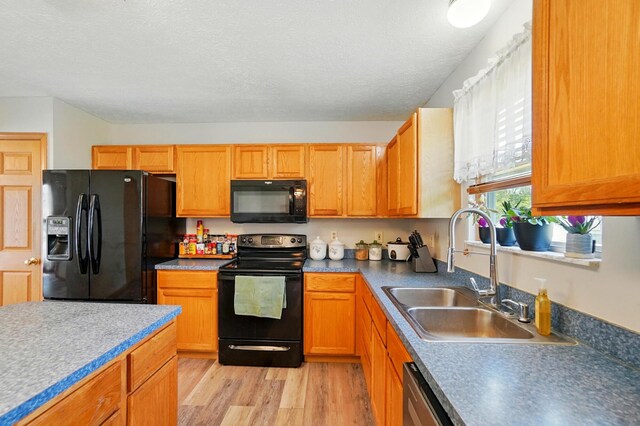 8578 Bivouac Pl, Galloway, OH 43119 - kitchen featuring black appliances, light wood-style flooring, and a textured ceiling