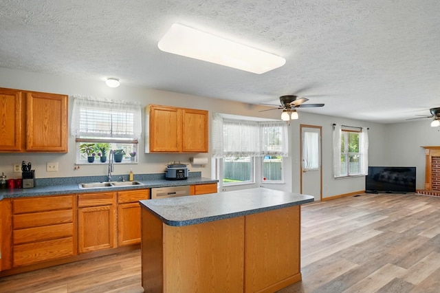 8578 Bivouac Pl, Galloway, OH 43119 - kitchen with ceiling fan, a textured ceiling, light wood finished floors, a center island, and dark countertops