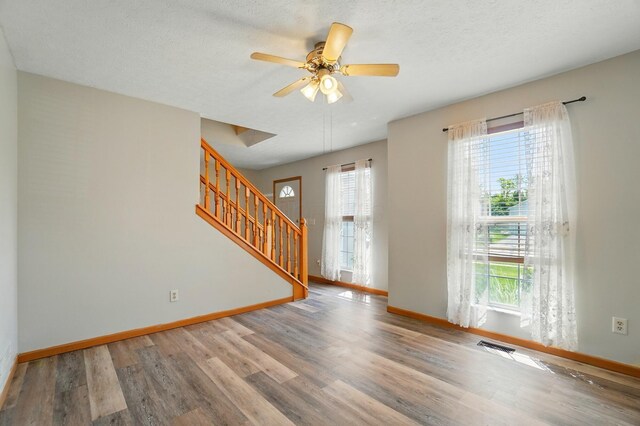 8578 Bivouac Pl, Galloway, OH 43119 - spare room with wood finished floors, stairs, a ceiling fan, and a textured ceiling