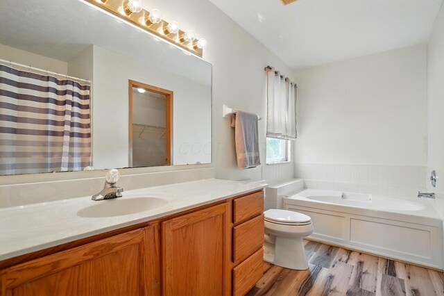 8578 Bivouac Pl, Galloway, OH 43119 - bathroom featuring vanity, a bath, wood finished floors, and curtained shower
