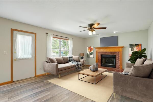 8578 Bivouac Pl, Galloway, OH 43119 - living area featuring wood finished floors, a ceiling fan, and a brick fireplace