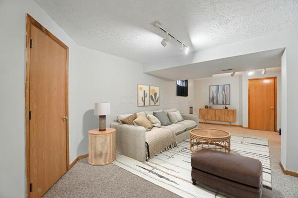 8578 Bivouac Pl, Galloway, OH 43119 - carpeted living room featuring rail lighting and a textured ceiling
