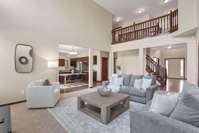 101 Stirling Way, Etna, OH 43062 - living area with stairs, a chandelier, light carpet, and a high ceiling