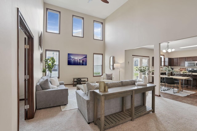 101 Stirling Way, Etna, OH 43062 - living room with light carpet, a towering ceiling, ceiling fan, and a chandelier