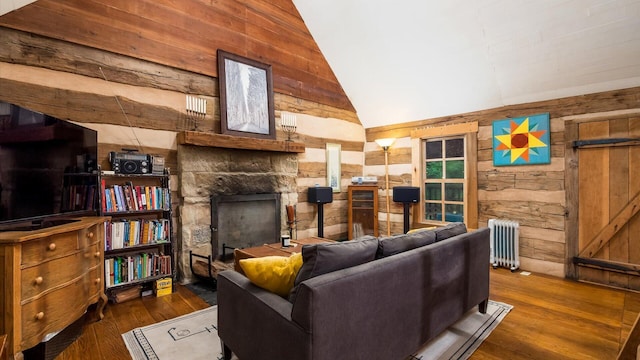24000 State Route 180, Rockbridge, OH 43149 - living room with wooden walls, radiator, wood finished floors, a fireplace, and high vaulted ceiling