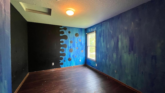 1080 Oxford Dr N, Pataskala, OH 43062 - empty room featuring wood finished floors, a textured ceiling, wallpapered walls, and attic access