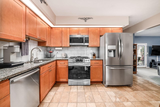 4051 Tamarack Ave, Grove City, OH 43123 - kitchen featuring appliances with stainless steel finishes, decorative backsplash, dark stone counters, and brown cabinetry