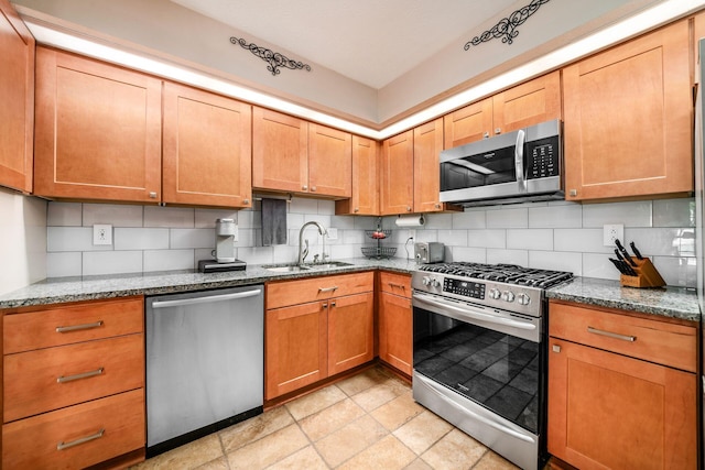 4051 Tamarack Ave, Grove City, OH 43123 - kitchen featuring stainless steel appliances, tasteful backsplash, dark stone countertops, and brown cabinetry